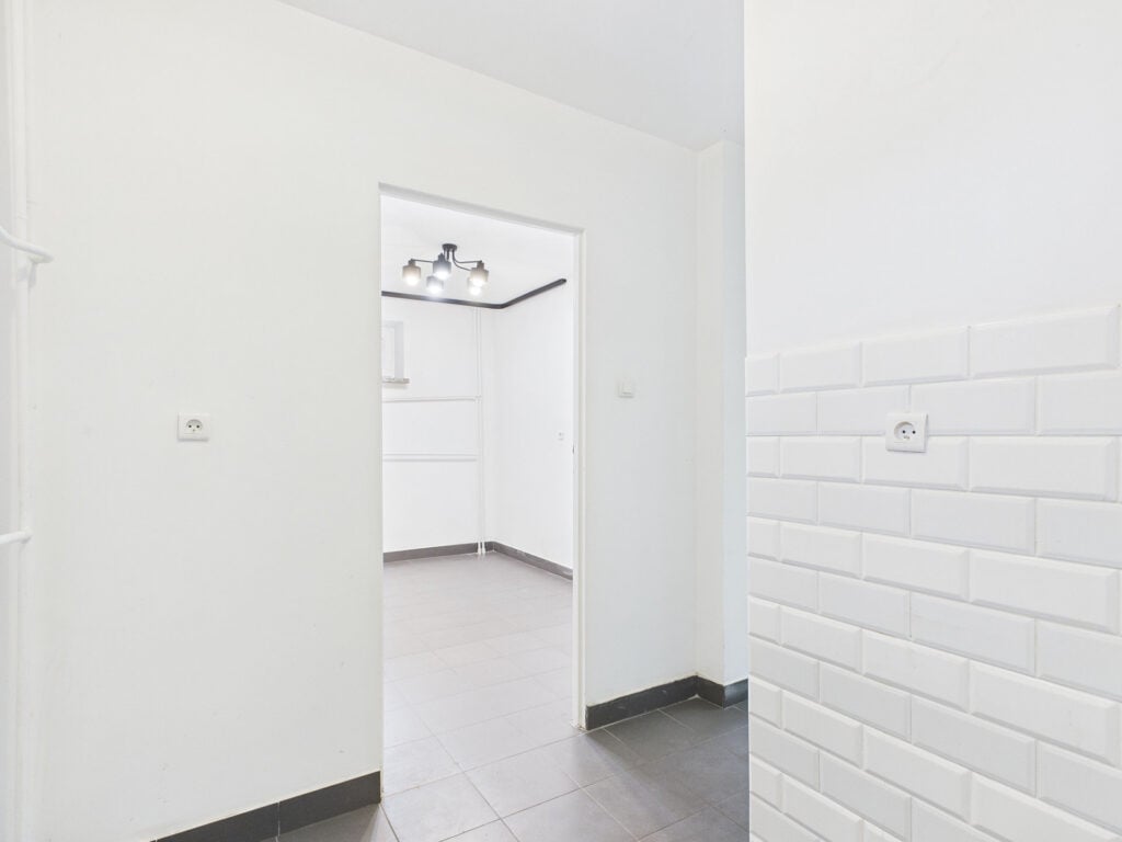 Pusty pokój z białymi ścianami i płytkami