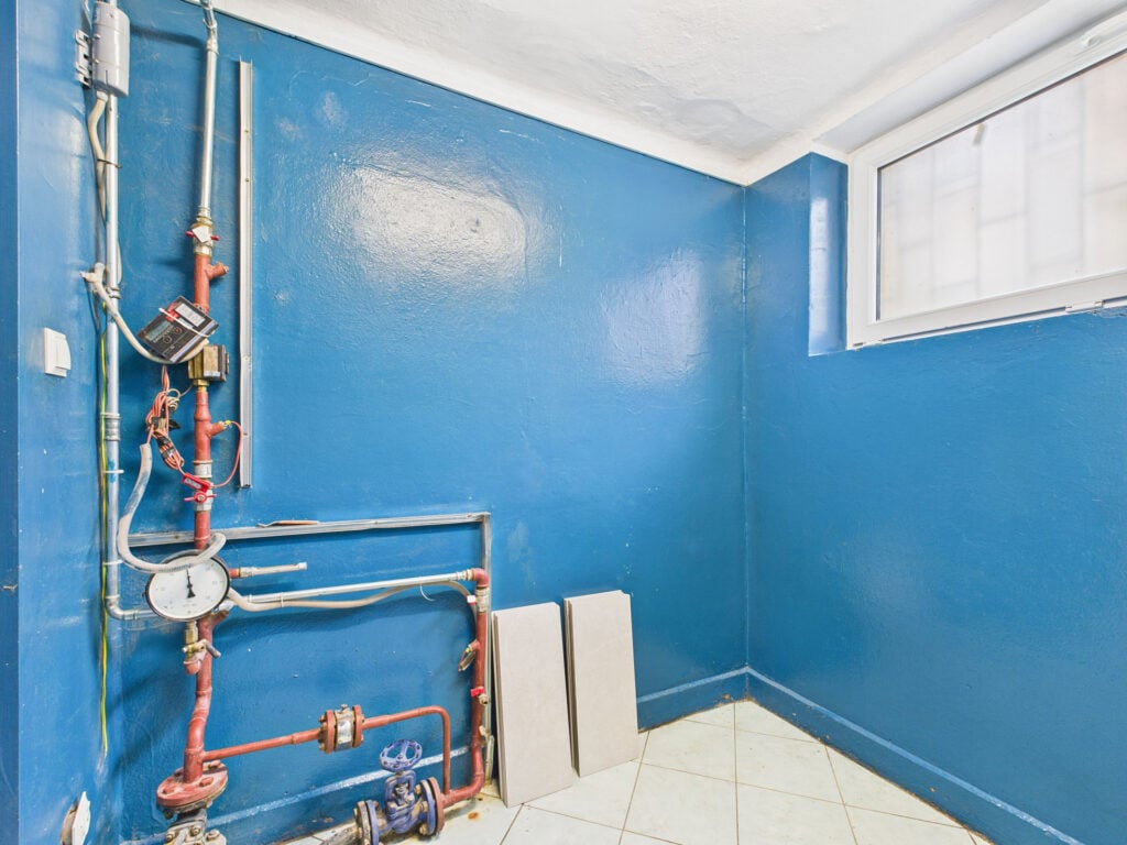 Niebieskie pomieszczenie gospodarcze z rurami i miernikami.