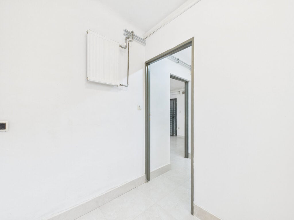 Wnętrze jasnej pustej klatki schodowej z kaloryferem.