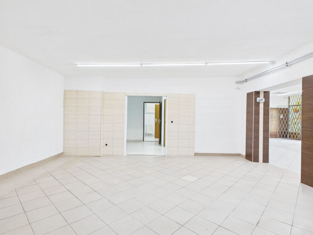 Puste pomieszczenie z oknami i jasnymi płytkami podłogowymi