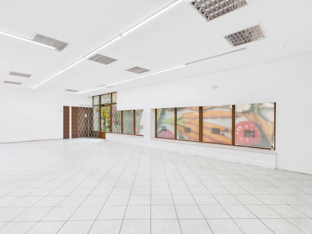 Pusta przestrzeń wewnętrzna z obrazami warzyw na ścianie.