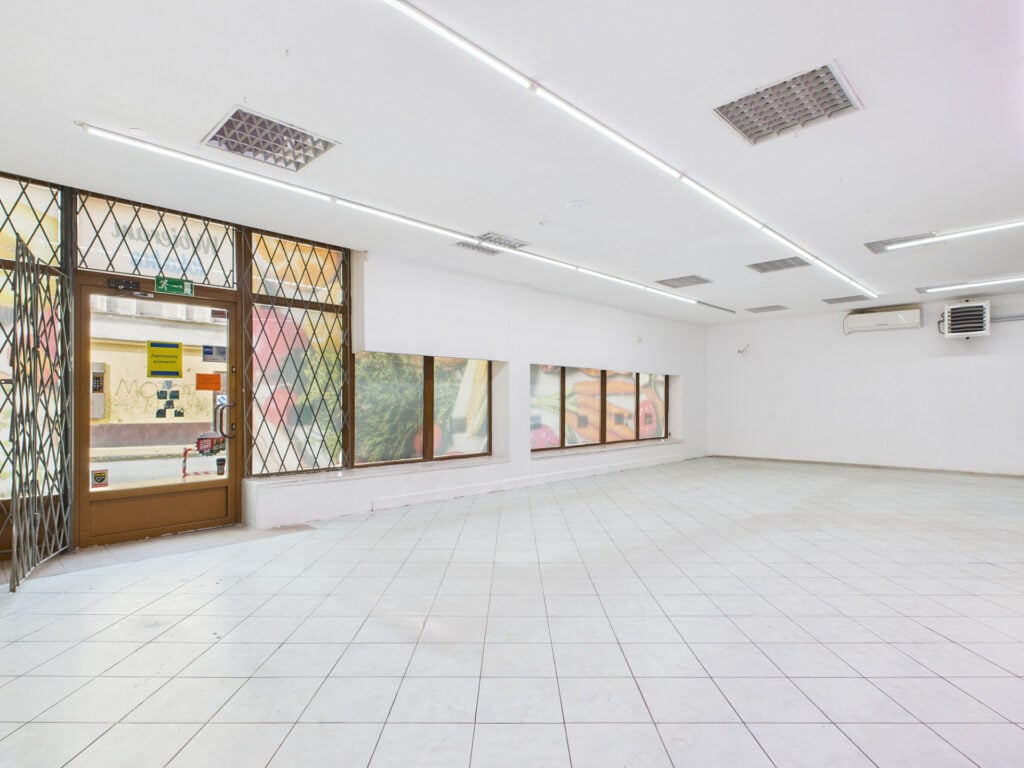 Pusta przestrzeń handlowa z dużymi oknami.