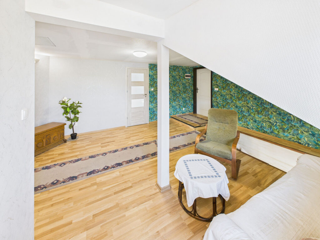 Wnętrze pokoju z rośliną i drewnianym krzesłem.