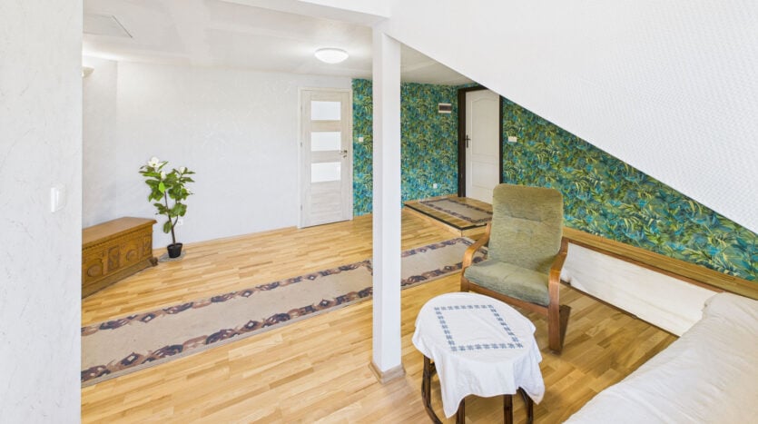 Wnętrze pokoju z rośliną i drewnianym krzesłem.