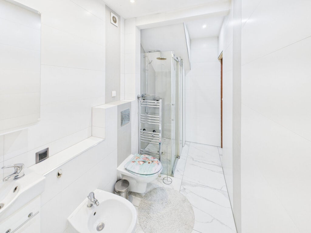 Nowoczesna biała łazienka z prysznicem i umywalką