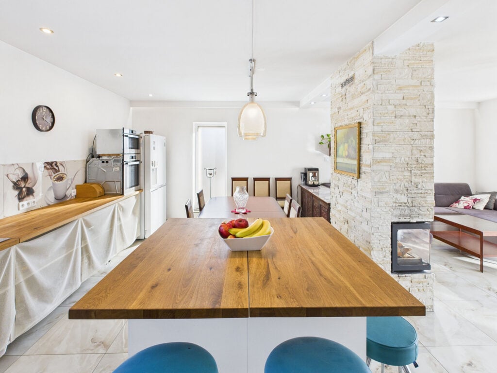Nowoczesna kuchnia z drewnianym stołem i dekoracyjną ścianą