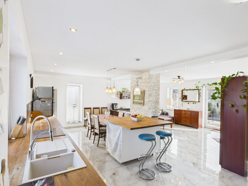 Nowoczesna kuchnia z drewnianymi blatami i białymi ścianami.