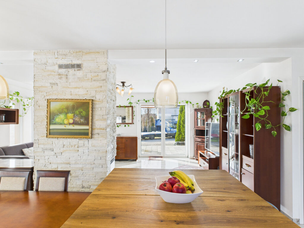 Nowoczesna kuchnia z drewnianym stołem i roślinami.