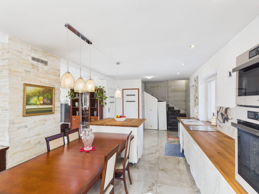 Nowoczesna kuchnia z drewnianym stołem i obrazem na ścianie