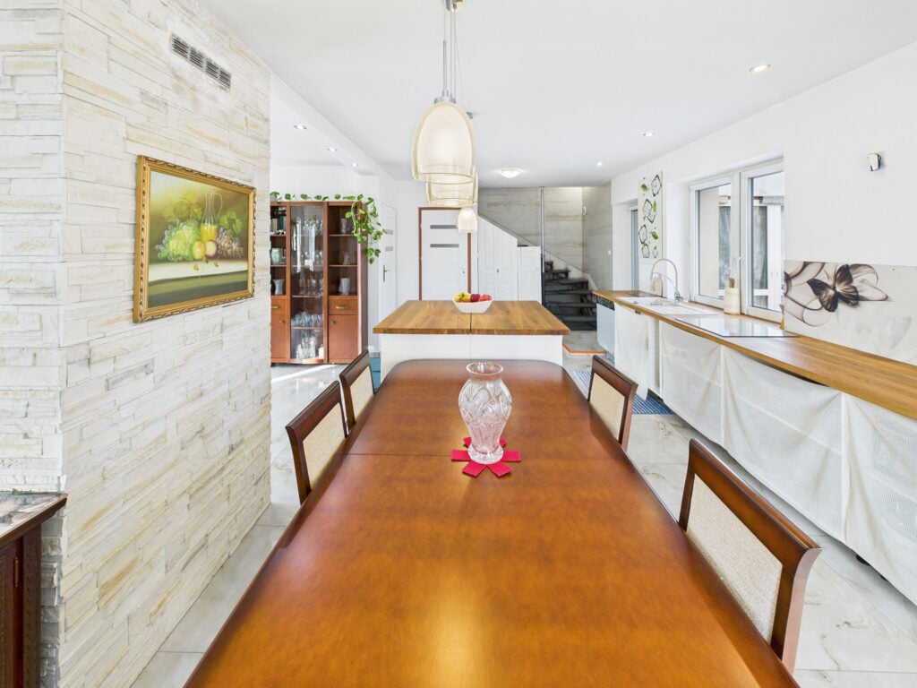 Stylowa jadalnia z drewnianym stołem i kuchnią