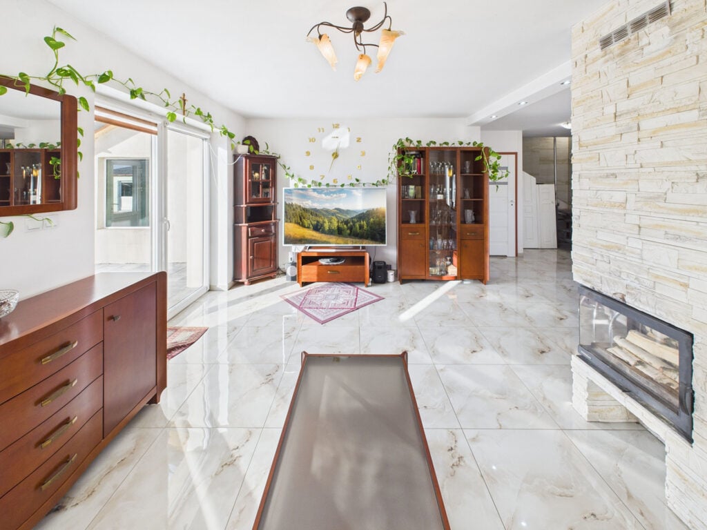 Elegancki salon z kominkiem i roślinami.