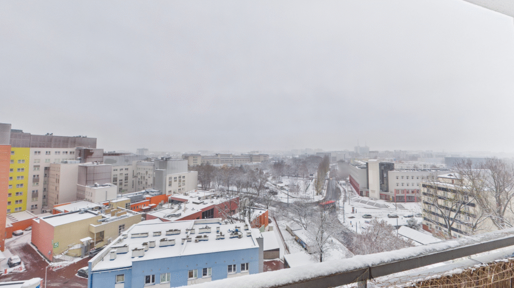Osiedle zimą pokryte śniegiem, kolorowe budynki.