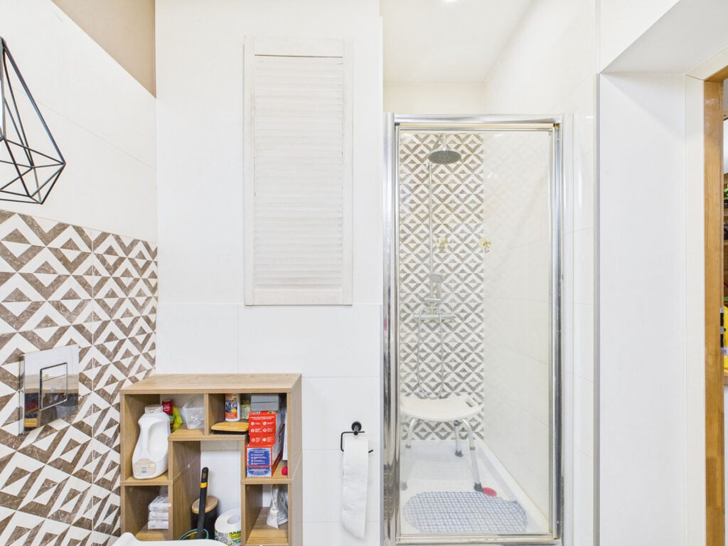 Nowoczesna łazienka z prysznicem i boazerią.