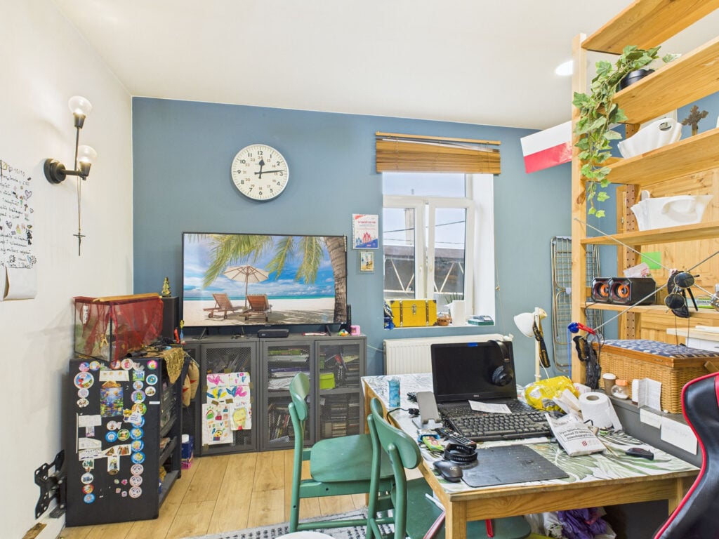 Domowe biuro z dekoracją ścienną i biurkiem.