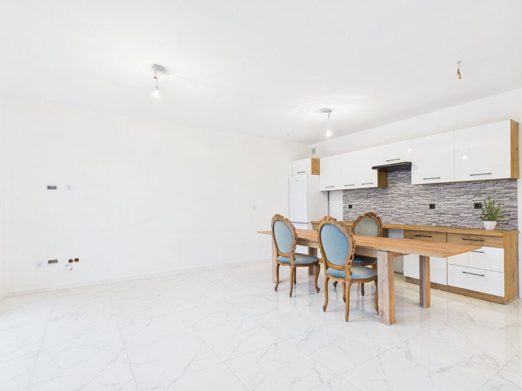 Przestronny salon z aneksem kuchennym i stołem