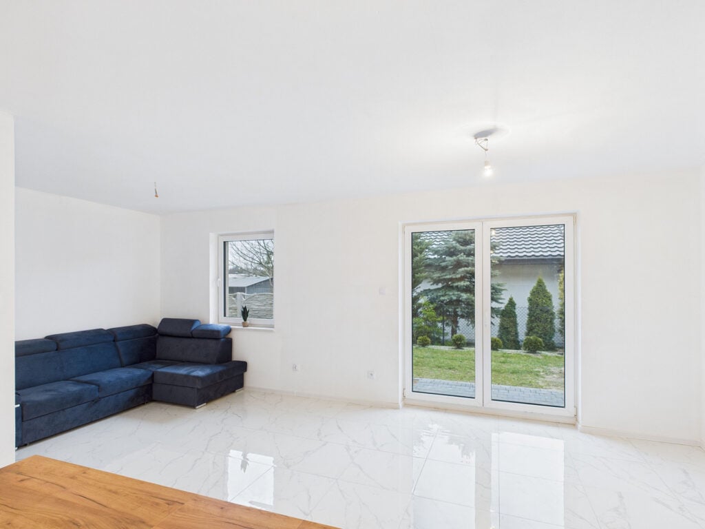 Nowoczesny salon z kanapą i dużymi oknami