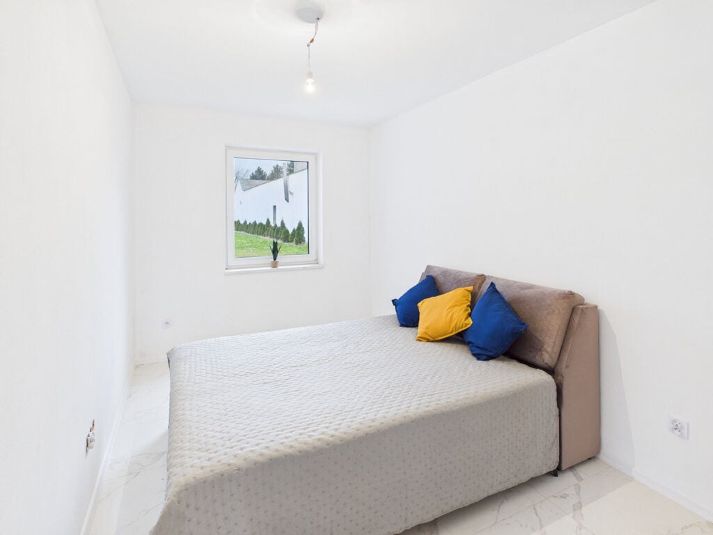 Minimalistyczna sypialnia z łóżkiem i poduszkami