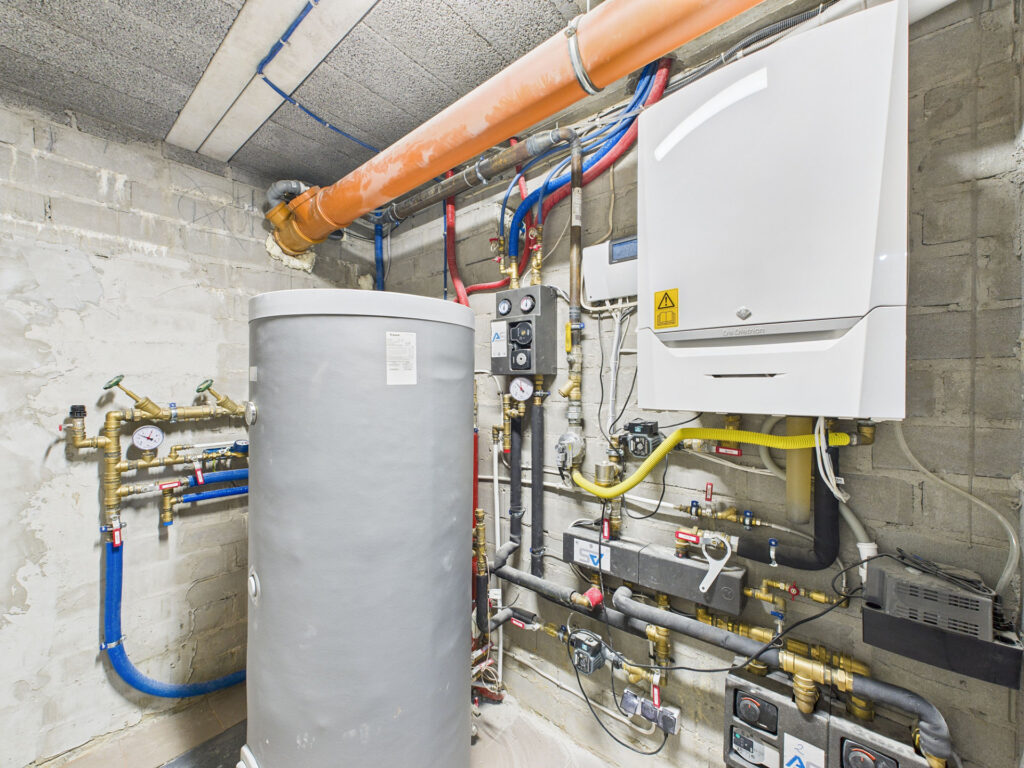 Kotłownia z piecem i zbiornikiem na wodę.