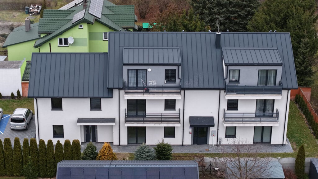 Dwupiętrowy budynek mieszkalny z nowoczesnym dachem.