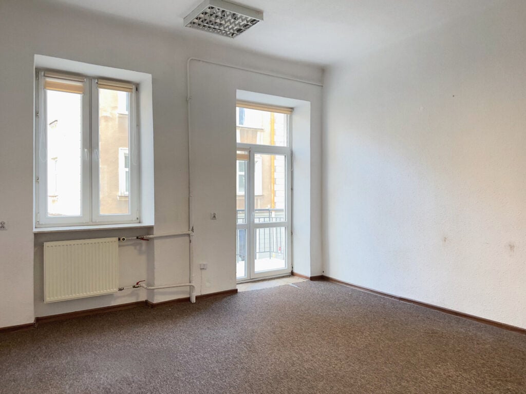 Puste mieszkanie z dużym oknem i balkonem.