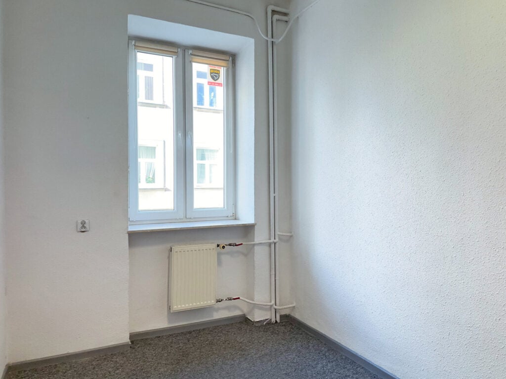 Puste pomieszczenie z oknem i kaloryferem
