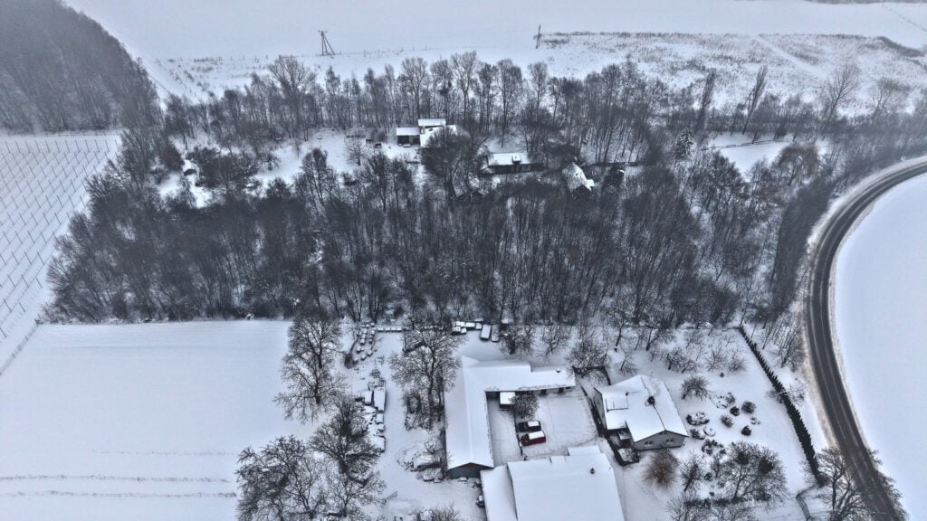 Podmiejska zima, widok z lotu ptaka, zasypane domy.