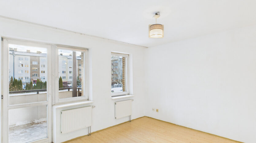 Jasny pokój z dużymi oknami i parkietem.