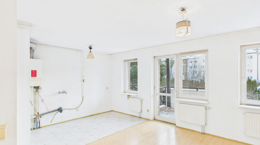 Puste mieszkanie z oknami i balkonem.